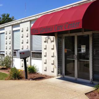 A modern building entrance with a red canopy and a mailbox in front.
