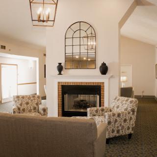 A warm and inviting living room featuring a decorative fireplace, stylish seating, and elegant lighting.