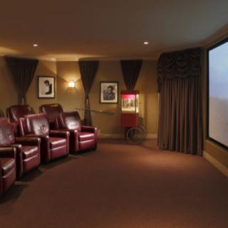 A luxurious home theater with comfortable leather seating and a large projector screen.