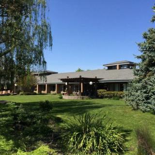 A beautiful house surrounded by lush greenery and trees on a sunny day.