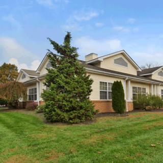 A suburban house surrounded by a well-maintained lawn and greenery.
