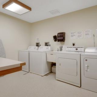 A laundry room with washing machines and dryers.