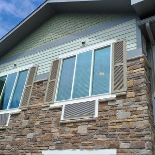 A residential building with a stone facade and multiple windows.