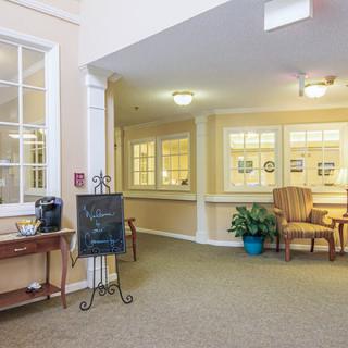 A cozy lobby area with seating, a plant, and a coffee station.
