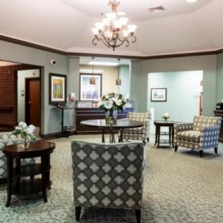 A cozy lobby area featuring comfortable seating, a chandelier, and elegant decor.