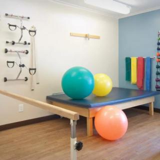 A physical therapy room equipped with exercise balls and rehabilitation equipment.