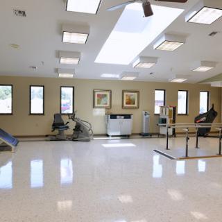 A spacious and well-lit rehabilitation therapy room equipped with various exercise tools.