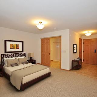 A cozy and well-furnished bedroom featuring a comfortable bed and warm lighting.