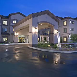 A well-lit hotel entrance at night, showcasing modern architecture.