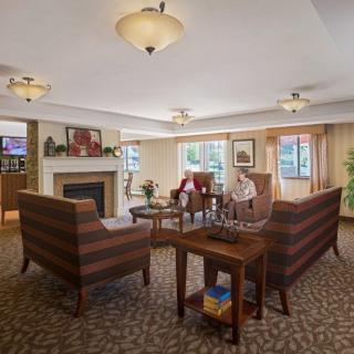 A cozy living room with a fireplace, seating area, and elegant decor.
