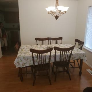 A dining room with a wooden table and chairs under a chandelier.