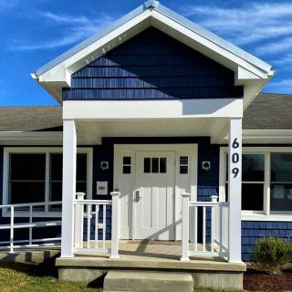 A modern blue house with a welcoming front porch.