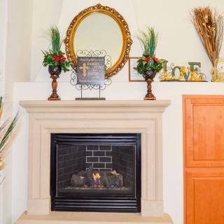 Cozy fireplace with decorative mantel and mirror.