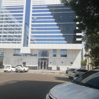 A modern office building with a sleek glass facade, showcasing contemporary architecture in an urban setting.
