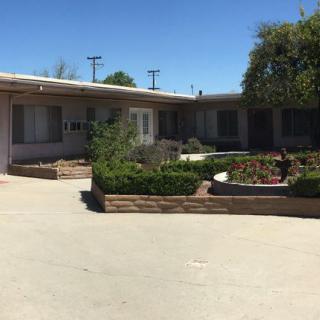 A residential building with a landscaped courtyard and driveway.
