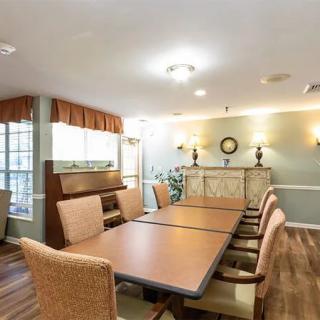 A well-lit dining room with a large table and comfortable chairs.