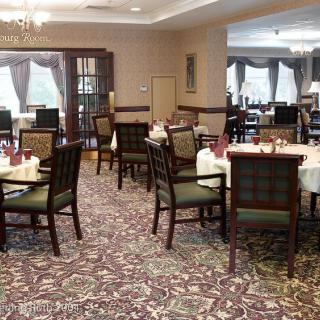 A spacious dining area with multiple tables and chairs, elegantly arranged for guests.