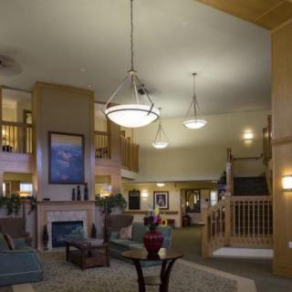 A spacious and well-decorated lobby with elegant lighting, comfortable seating, and a staircase.