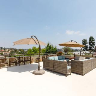 A sunny outdoor patio with comfortable seating and large umbrellas.