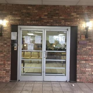 Main entrance with double glass doors featuring a brick facade.