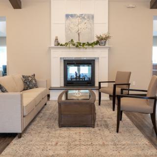 A cozy and modern living room featuring a stylish sofa, comfortable chairs, and a fireplace.