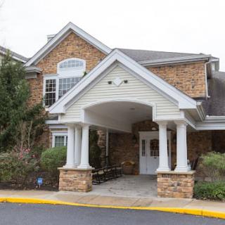 An exterior view of a building entrance with columns and brickwork.