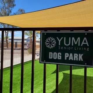 A welcoming view of the Yuma Senior Living Dog Park, complete with lush green grass and shaded areas for pets to enjoy.