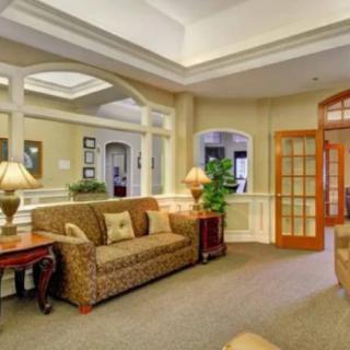 A cozy living room with elegant decor, featuring a patterned sofa, lamps, and glass doors.