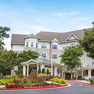 A beautifully landscaped hotel with a welcoming entrance and an American flag flying.