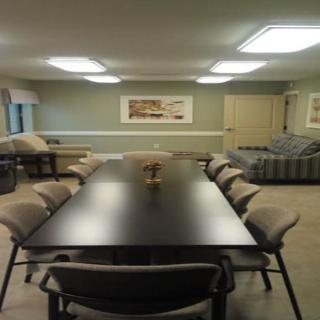 A conference room with a long meeting table and several chairs.