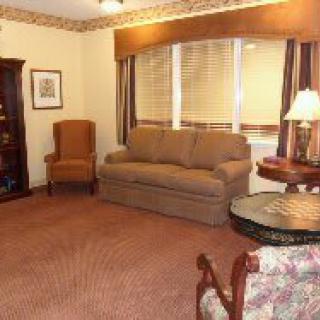 Cozy living room with a sofa, armchair, and warm lighting.