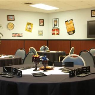A meeting room set up with round tables and chairs, decorated with various wall posters.