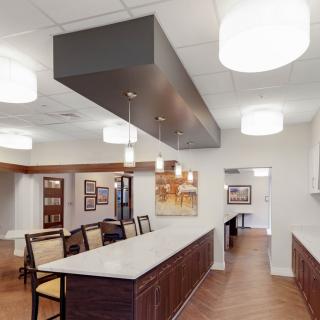 A modern dining and kitchen area with contemporary lighting and art decor.