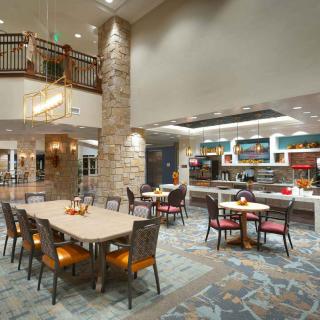 A modern dining area with tables and chairs, featuring stylish lighting and decor.