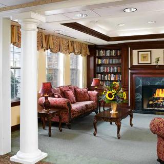A traditional living room with elegant furnishings, featuring a cozy fireplace and built-in bookshelves.