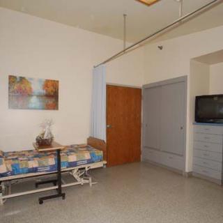 A clean and organized hospital room with a bed, TV, and minimal decor.