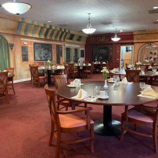 A well-decorated restaurant dining room with neatly arranged tables and chairs.
