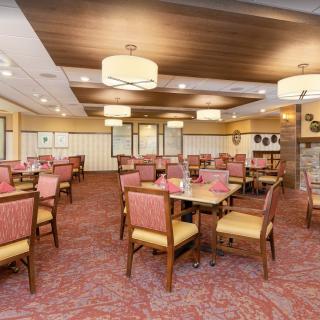 A spacious dining room with elegant furniture and warm lighting.