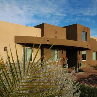 A modern southwestern-style house surrounded by desert landscaping.