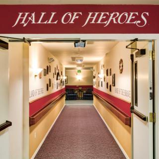 A hallway labeled 'Hall of Heroes' with open doors and decorated walls.
