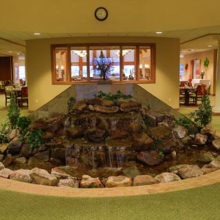An indoor waterfall feature in a lobby setting with rocks and plants.