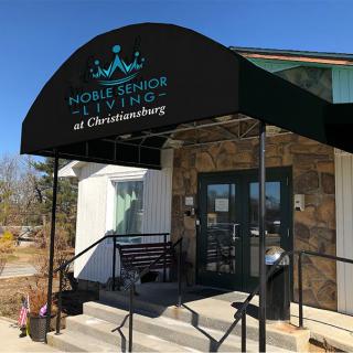 Entrance to a business with a stone exterior and an awning.