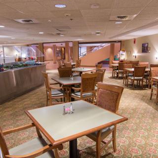 An empty restaurant dining area with neatly arranged tables and chairs.