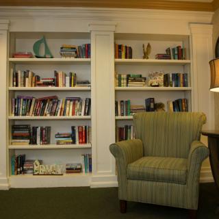 A cozy reading corner with a bookshelf and armchair.