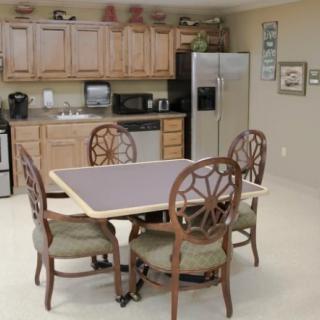 A cozy kitchen and dining area with a table and chairs, wooden cabinets, and modern appliances.