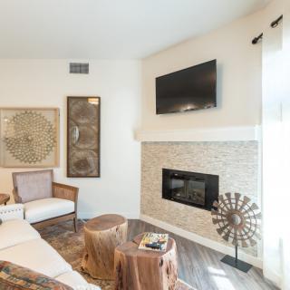 A modern living room with a fireplace, wall-mounted TV, and stylish artwork.