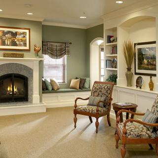 A cozy traditional living room with a fireplace, comfortable armchairs, and elegant decor.