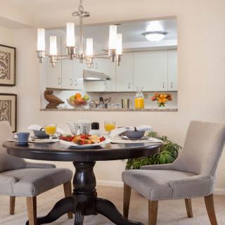 A cozy dining area with a beautifully set breakfast table and elegant chandelier.