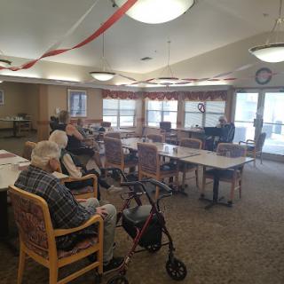 A cozy community center activity room, where elderly residents gather for socialization.