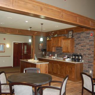 A cozy kitchen space with wooden cabinetry, a seating area, and a coffee station.